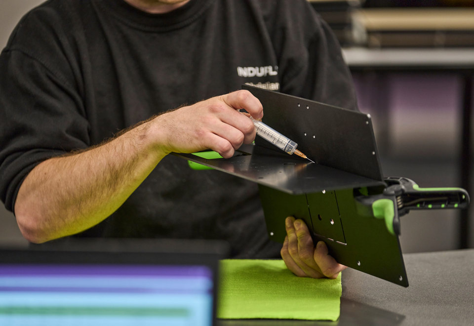 To dele i sort ABS limes sammen med en sprøjte med klar lim.