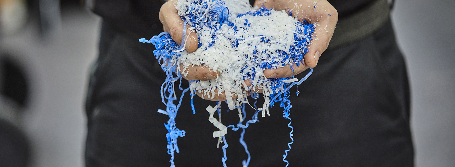 Hands holding chips in blue and white from a cutting processing