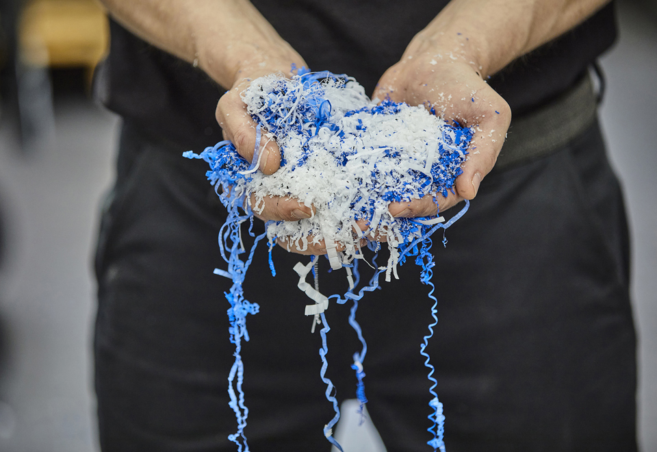 Hands holding chips in blue and white from a cutting processing