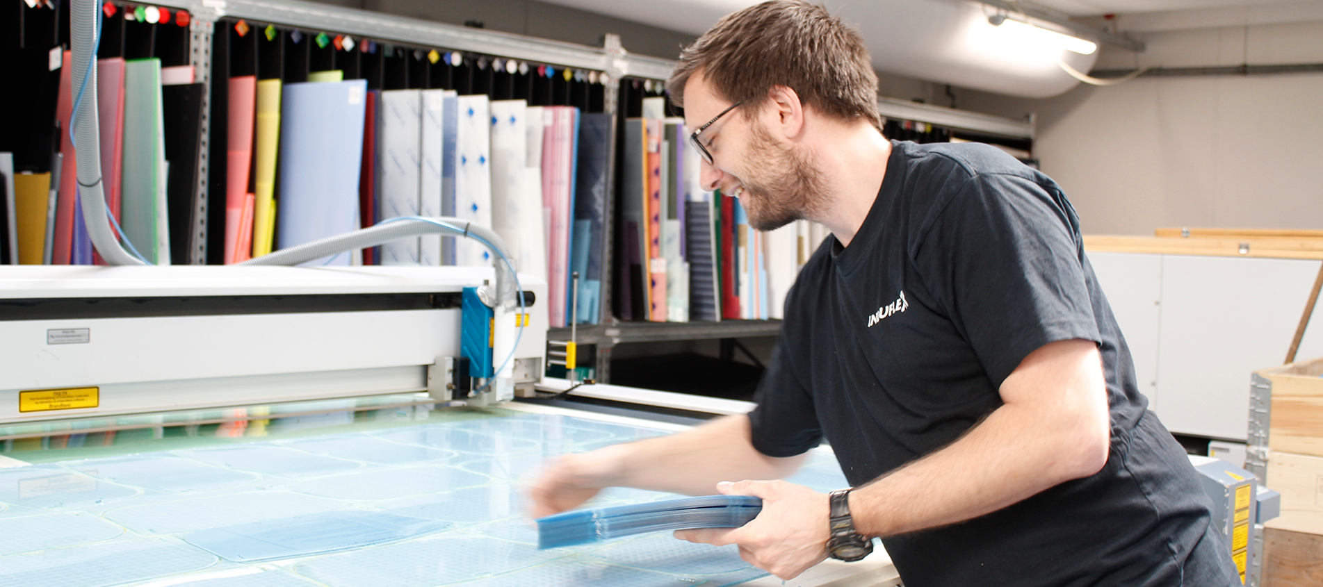 Industry technician in the laser workshop lasser cutting screens for face visors in clear PET