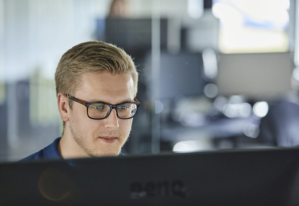 Sælger hos Induflex sidder klar ved computer til at behandle din forespørgsel