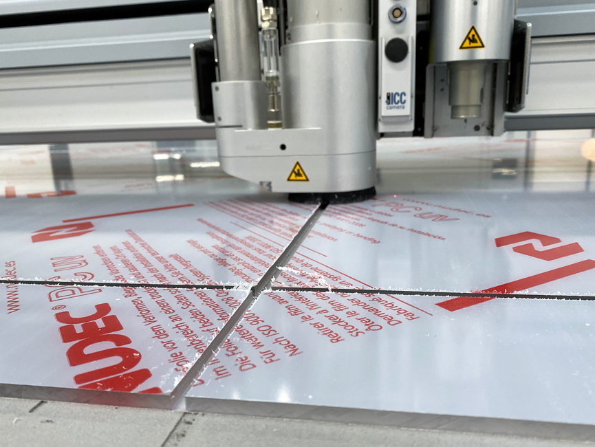 Skæreplotter fræser riller i en gennemsigtig plade af polycarbonat