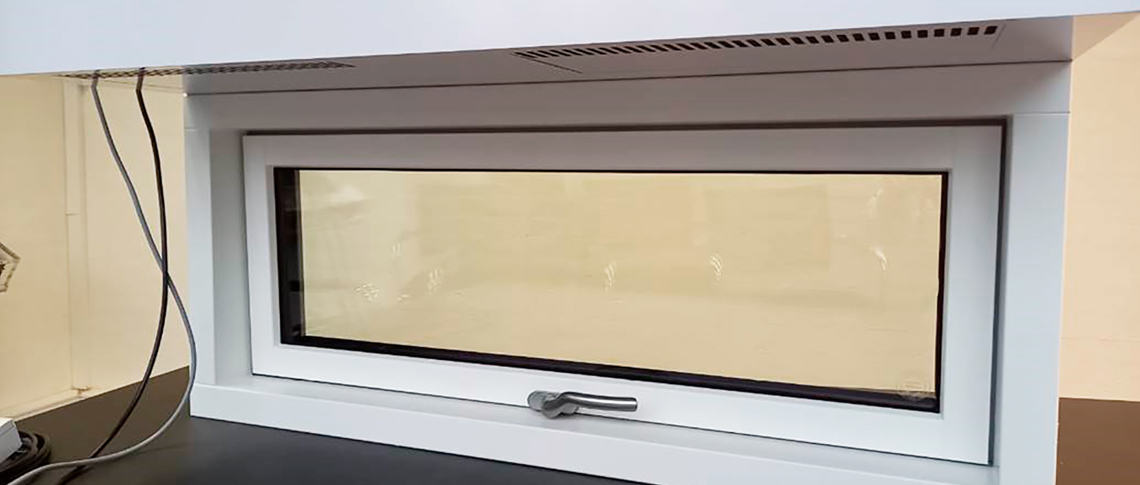 Hvidt vindue med indbygget ventilationssystem med speciallavet coverløsning