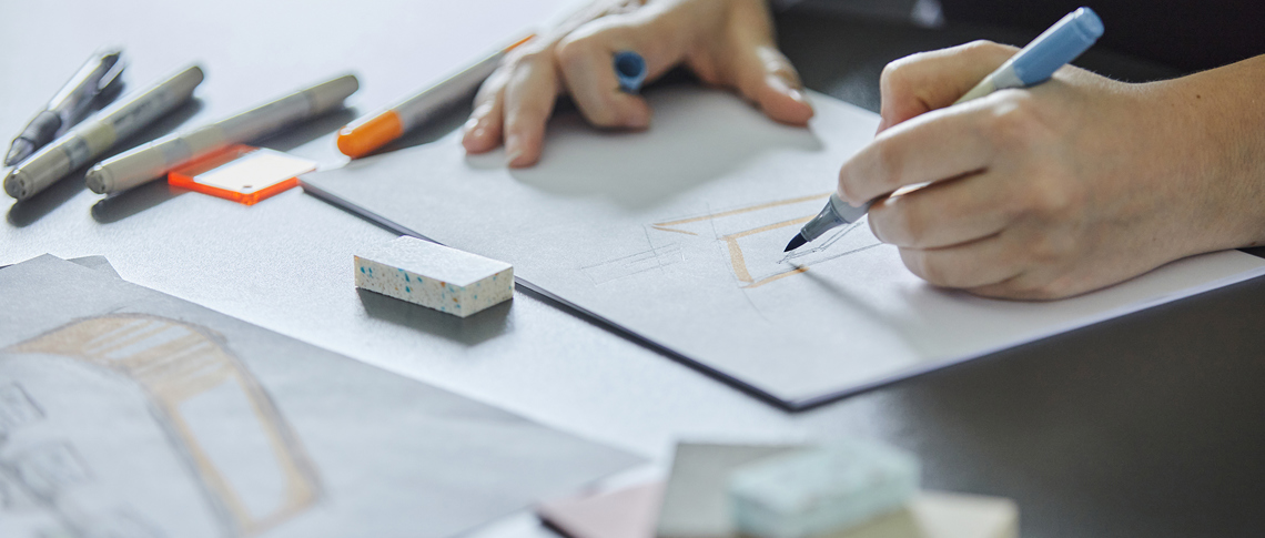Designer draws with drawing ink sketches of podiums in plastic