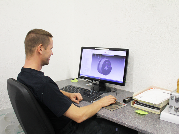 Industry technician at Induflex preparing for programming before production of a machine part in plastic