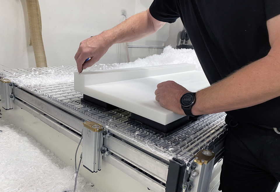 En industritekniker hos Induflex afgrater en maskindel af PEHD