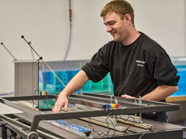 An employee closes a heat-bending table.