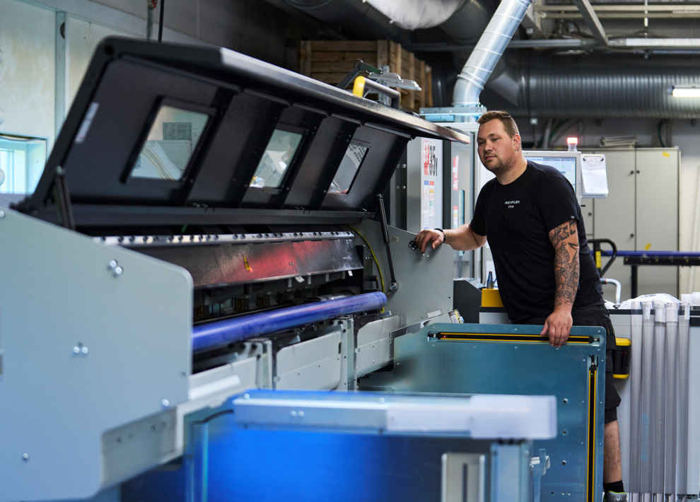 Industritekniker sikrer stanglader på CNC-drejer.