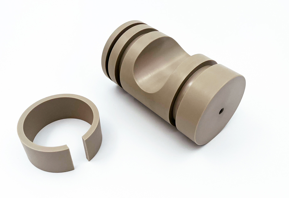 Two CNC-turned machine parts of PEEK on a white background.
