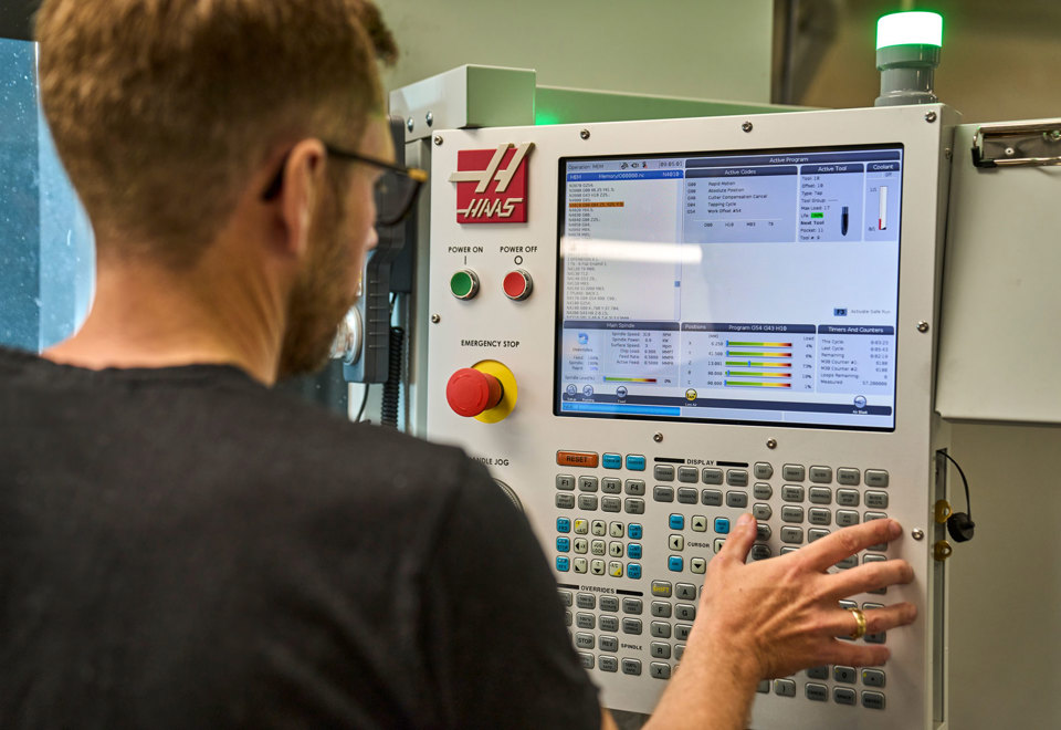 En industritekniker indstiller en maskine i Induflex’ produktion. 