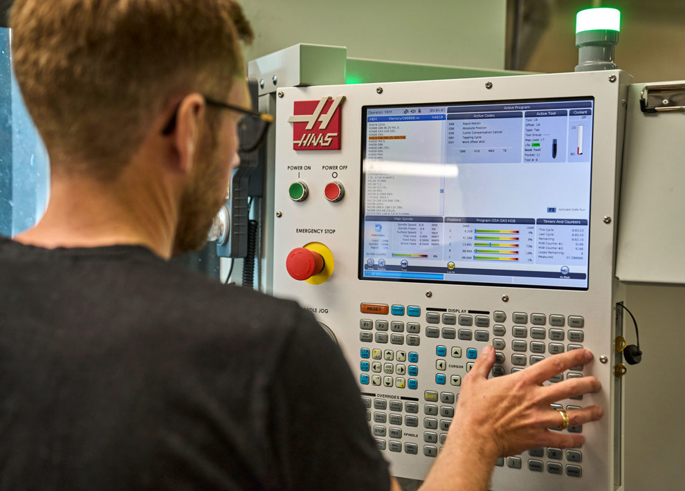 En industritekniker indstiller en maskine i Induflex’ produktion. 