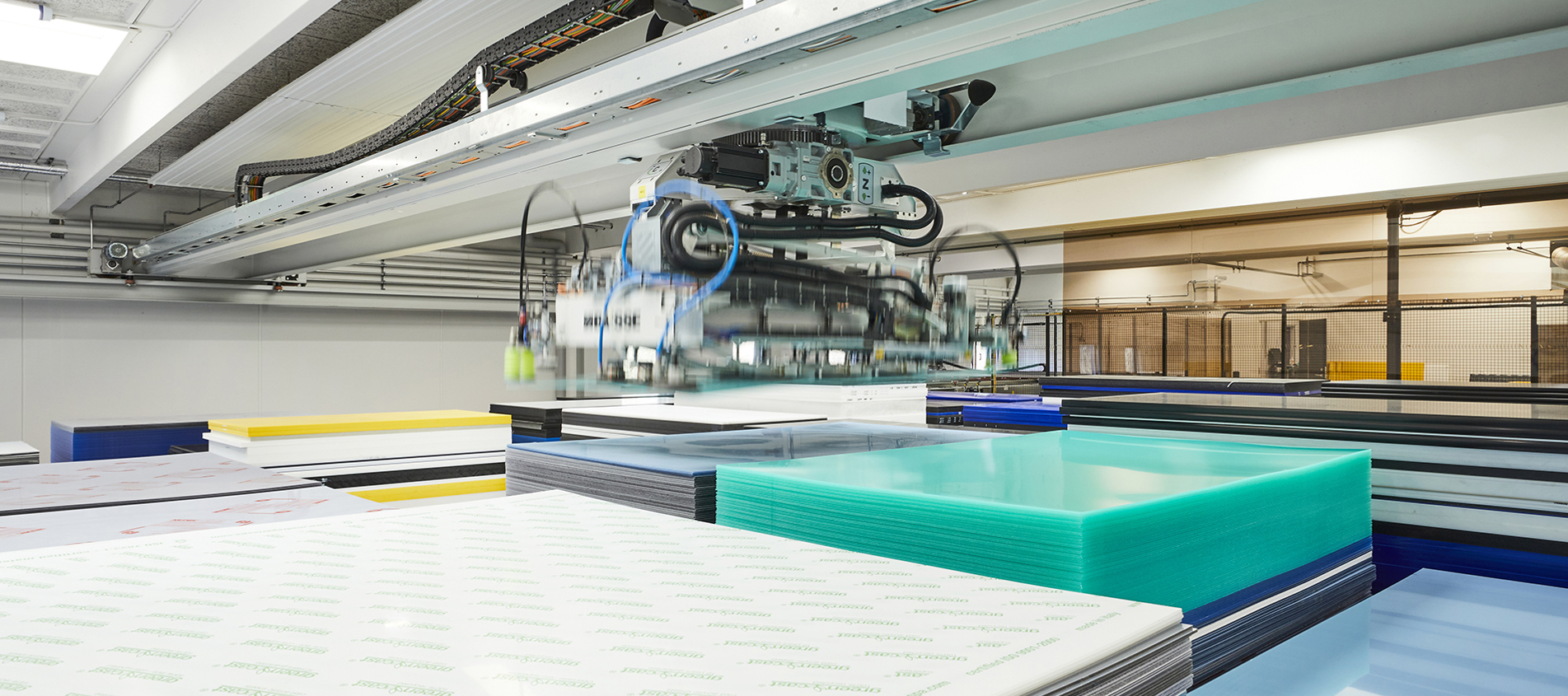 Crane picking up plastic sheets in Induflex's automatic sheet storage