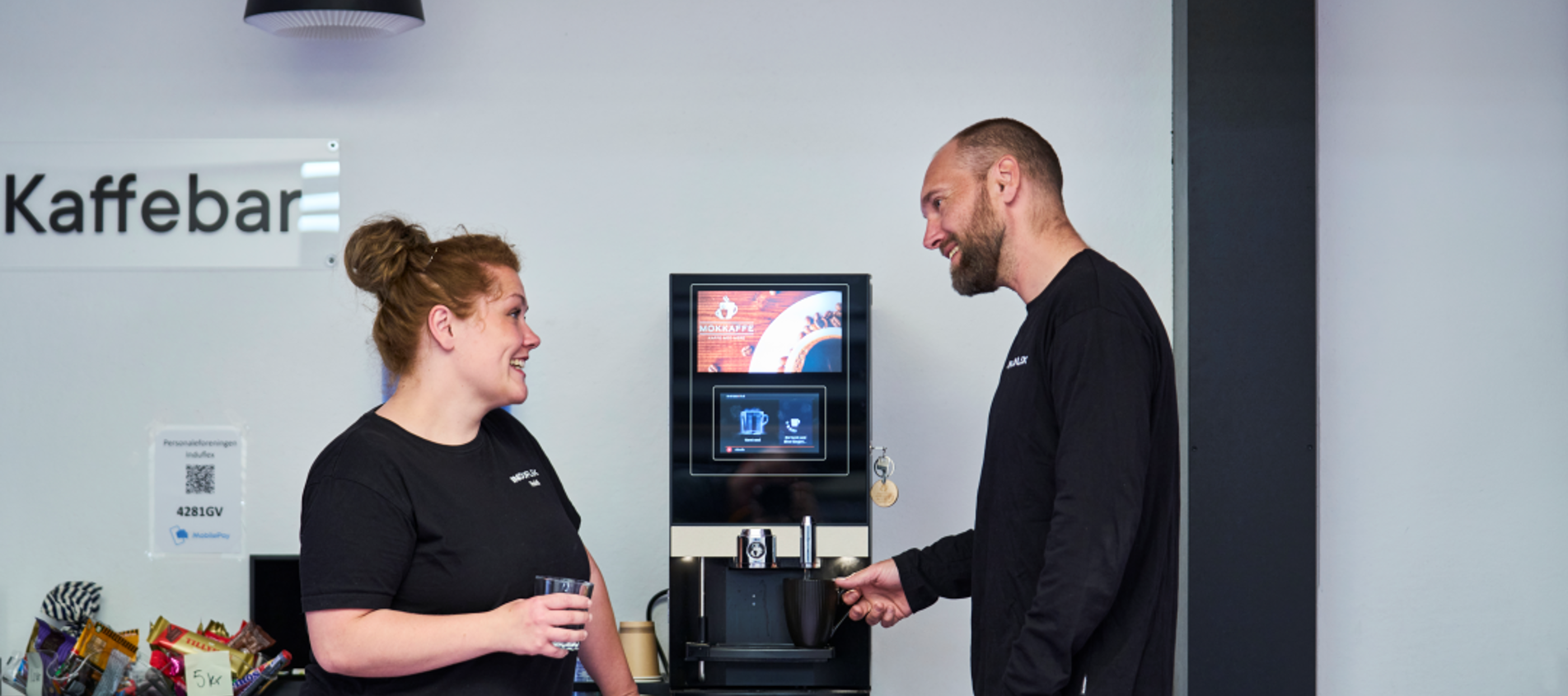 Kolleger snakker om dagen ved kaffemaskinen. 