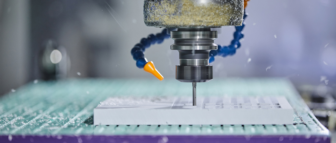 CNC-fræser fræser et emne ud i hvid plast med mange huller