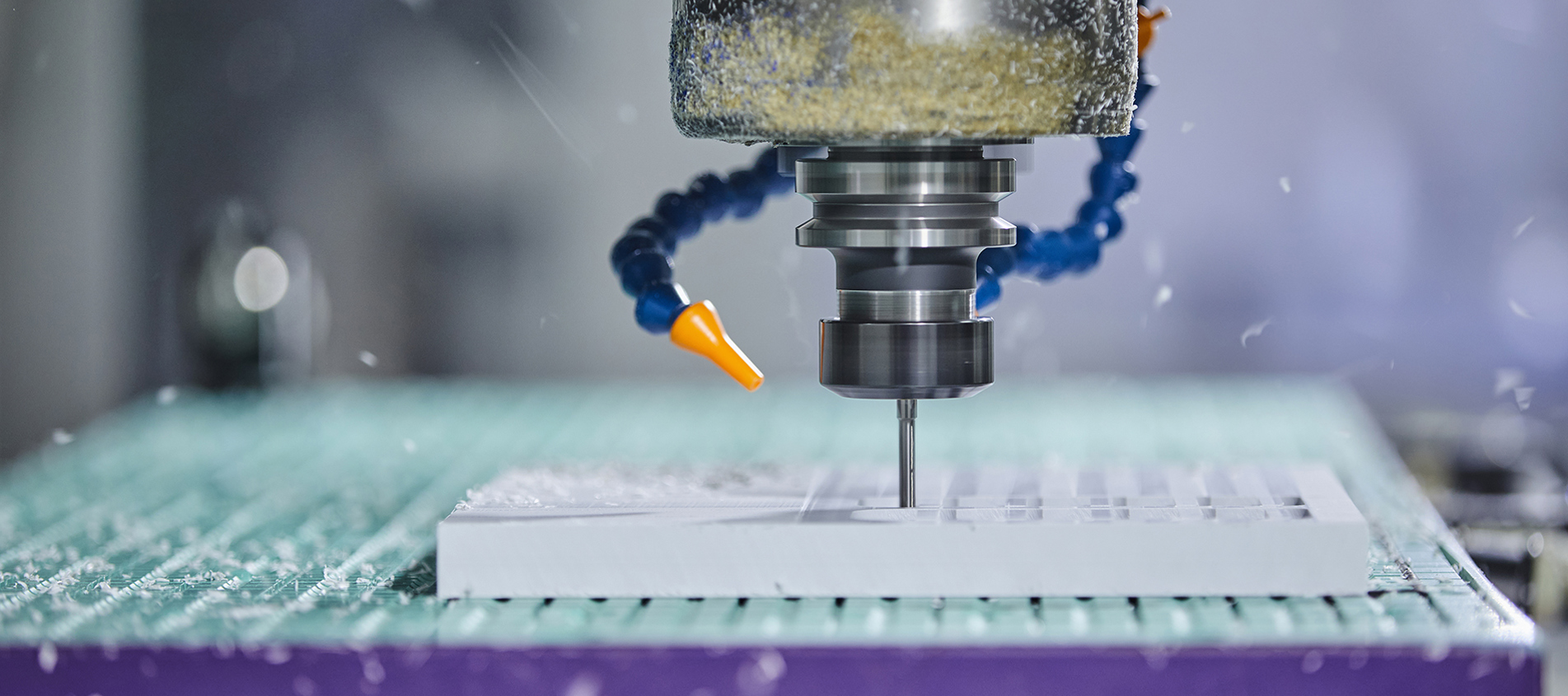 CNC-fræser fræser et emne ud i hvid plast med mange huller