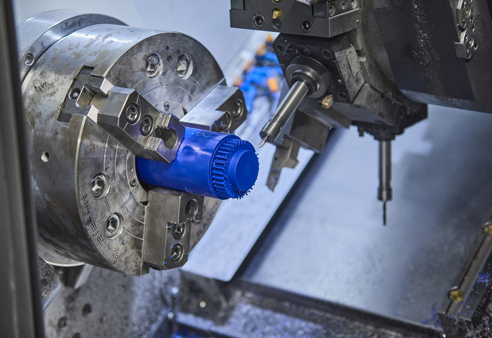 CNC-drejning af et tandhjul i blå plast med mange takker