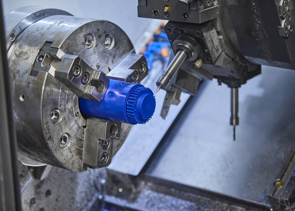 CNC-drejning af et tandhjul i blå plast med mange takker