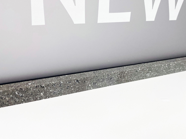 Gråt skilt med teksten new af akryl med en fod af corian