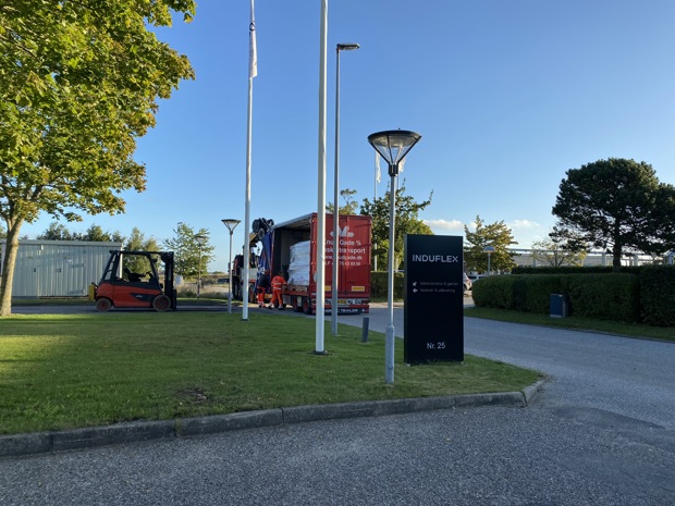 En lastbil foran Induflex med en maskine i