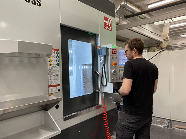 En industritekniker betjener en fem-akset CNC-fræser