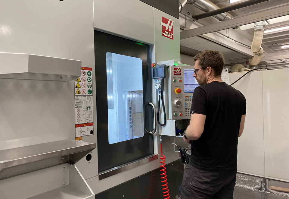 En industritekniker betjener en fem-akset CNC-fræser