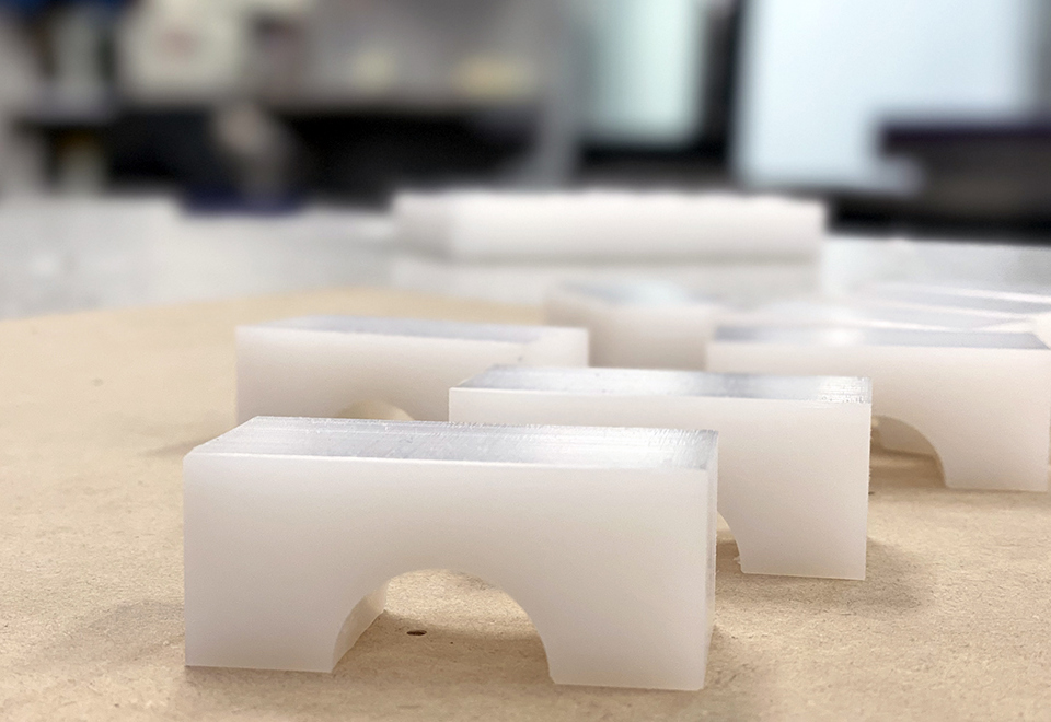 CNC-fræsede emner i hvid teknisk plast i Induflex' tekniske værksted