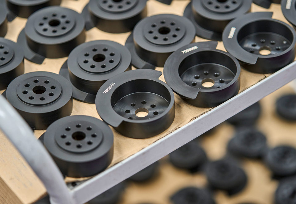 A table full of black machine parts with engraved numbers.