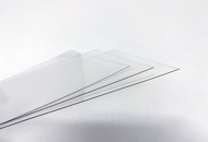 Three thin sheets of clear PET plastic on a white background
