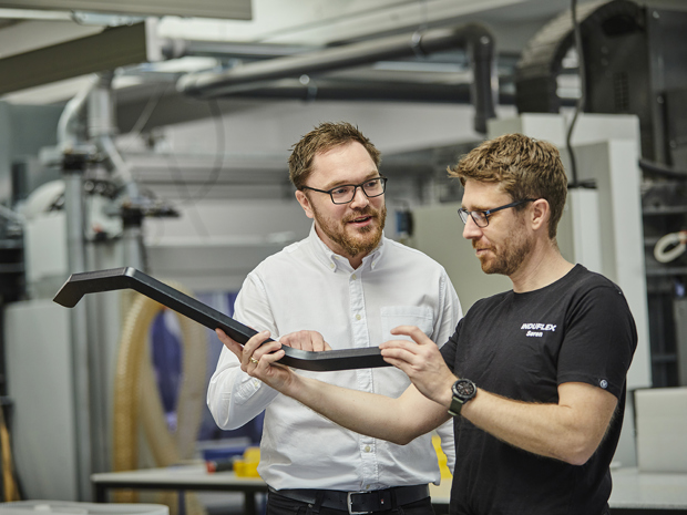 Industry technician shows Sales Manager details on a plastic part in the cutting workshop