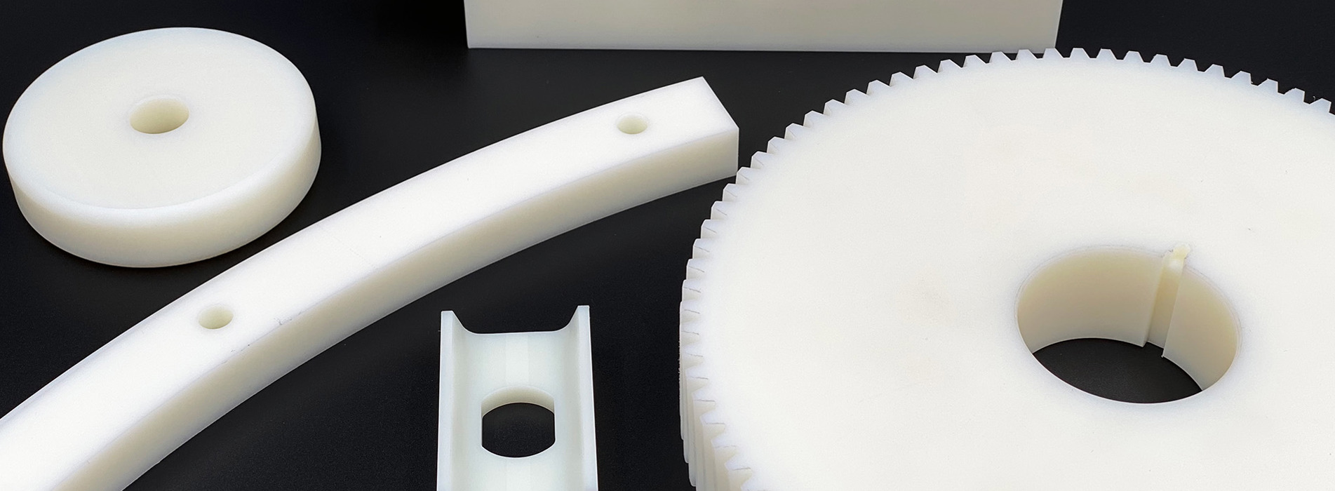 Fem forskellige maskindele lavet af hvidt nylon plast