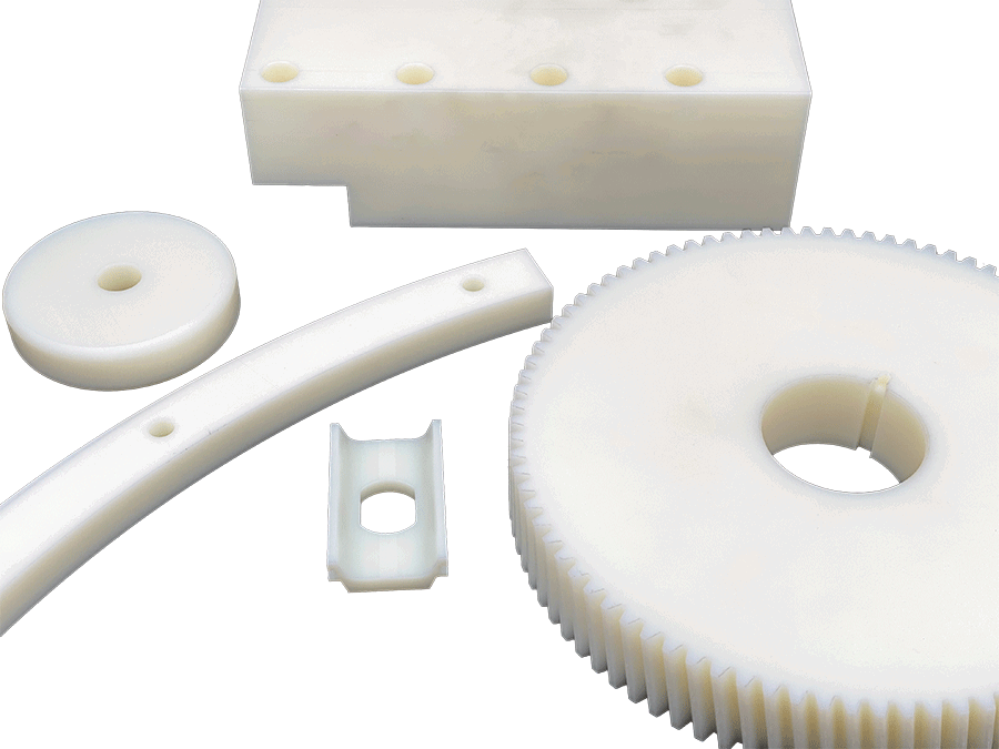 Fem forskellige maskindele lavet af hvidt nylon plast
