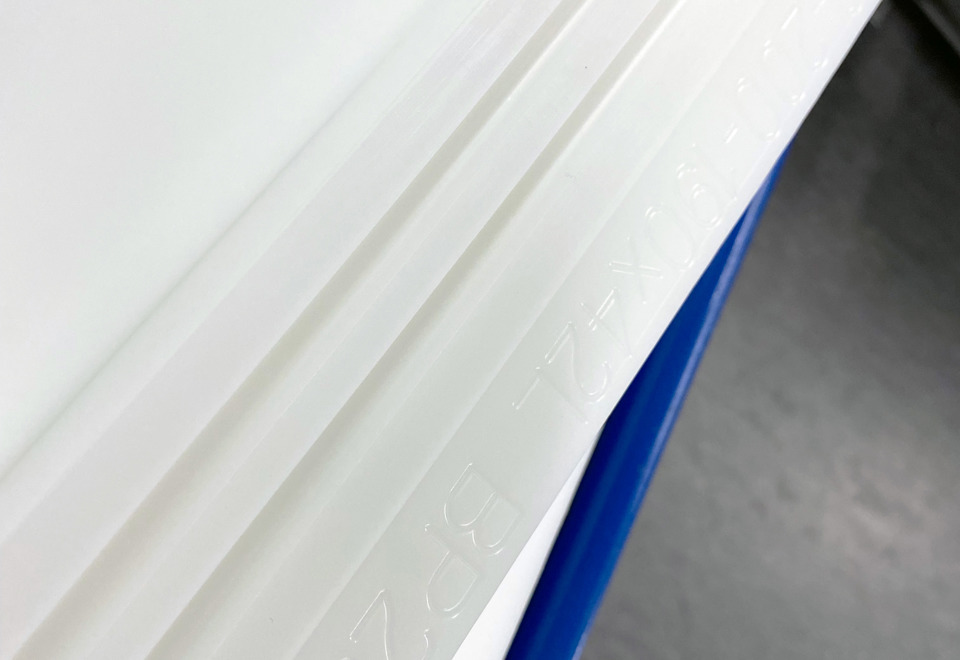 En plastdel i hvid PEHD med indgraverede numre