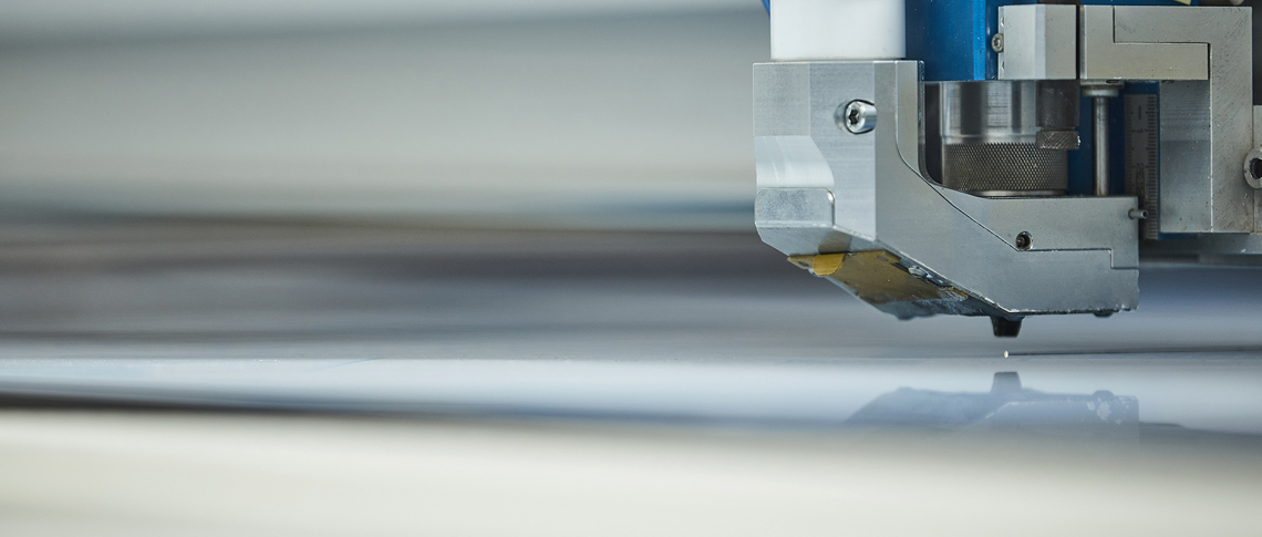 Laser cutter cuts a sheet of transparent acrylic at Induflex