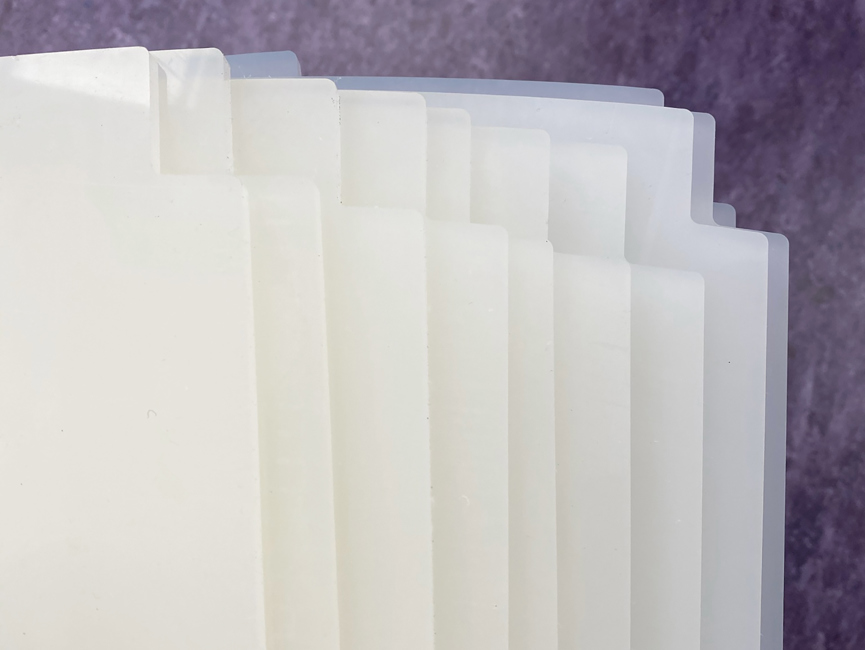 Plader i naturfarvet polypropylen der er skåret ud på laserskærer