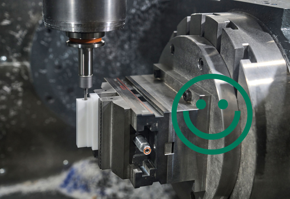 A white machine part made from plastic is being milled