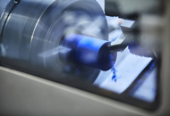 CNC-drejebænk i Induflex' produktion drejer et emne i blåt plast
