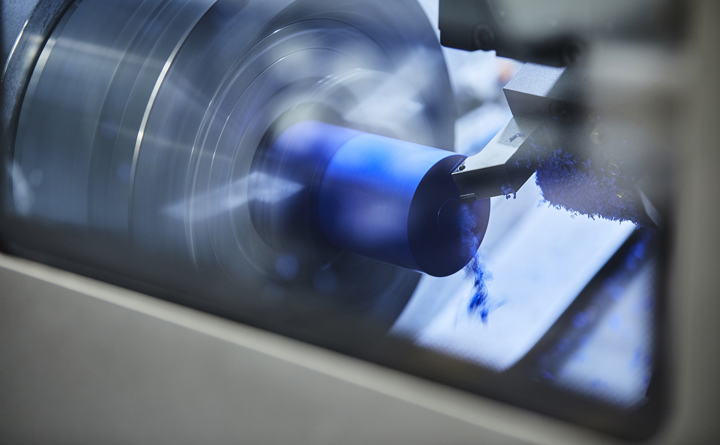 CNC-drejebænk i Induflex' produktion drejer et emne i blåt plast