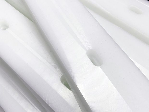 CNC processed plastic parts with holes in white plastic