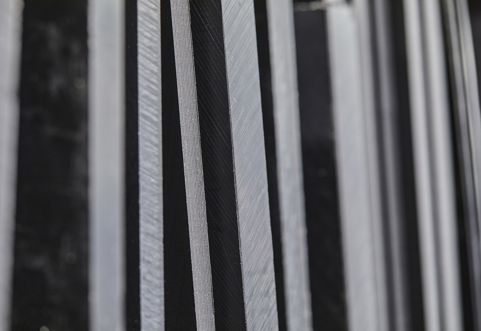 Sheets of black technical plastics on a shelf at Induflex's inventory in Støvring