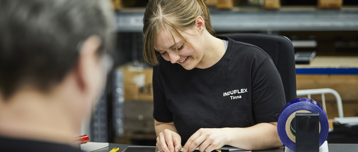 Assembly worker mounts foil on a part in the assembly department at Induflex