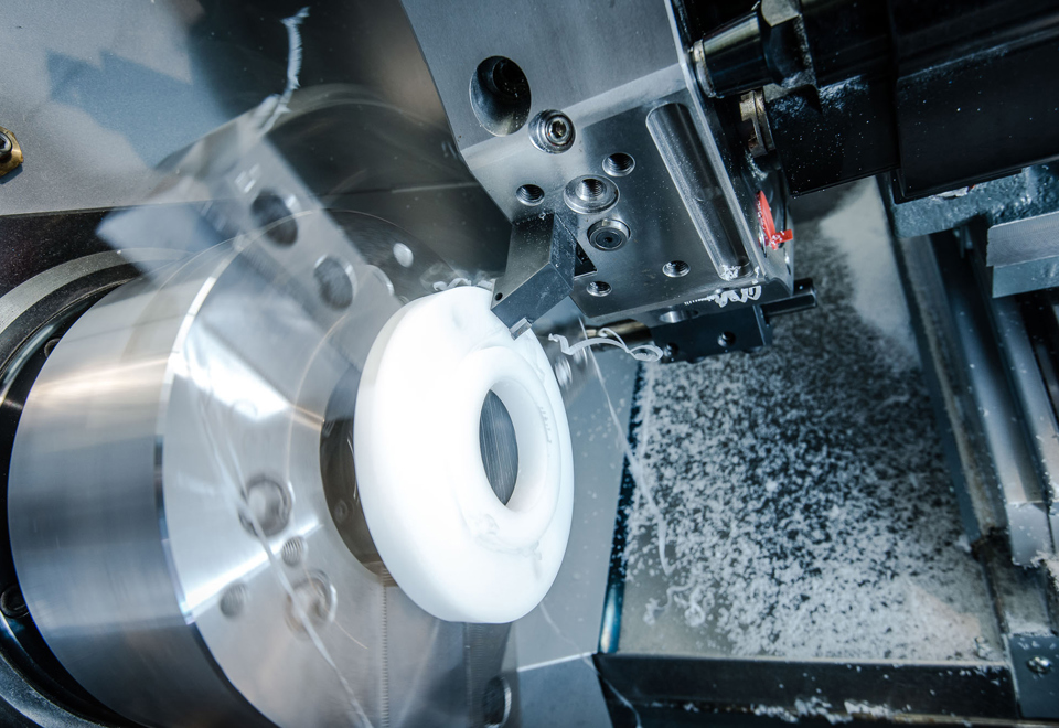 CNC-drejemaskine drejer et fødevaregodkendt plast emne i hvidt plast