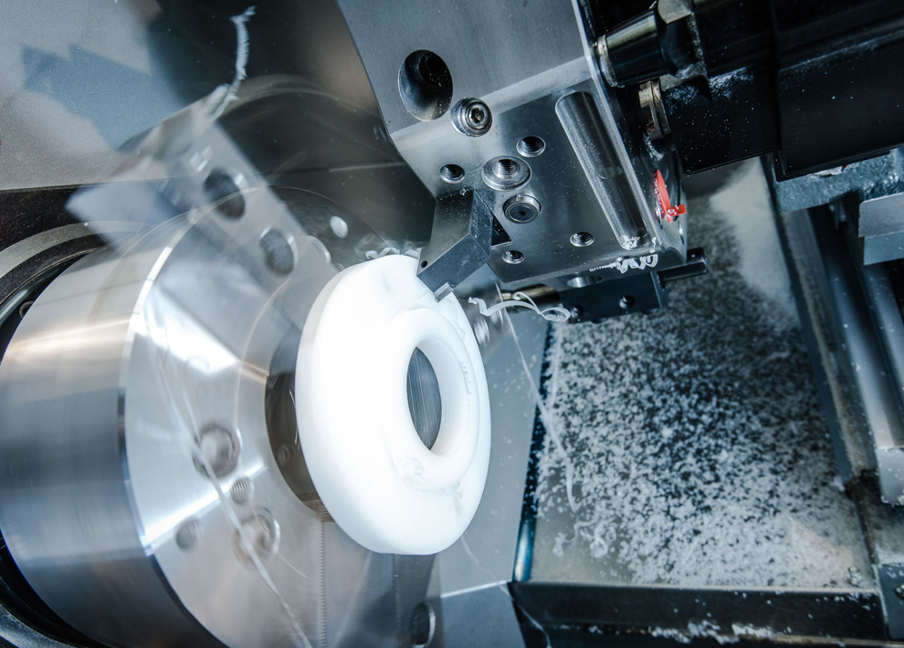 CNC-drejemaskine drejer et fødevaregodkendt plast emne i hvidt plast