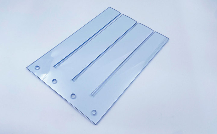 Gennemsigtigt bændelgardin på hvid baggrund.