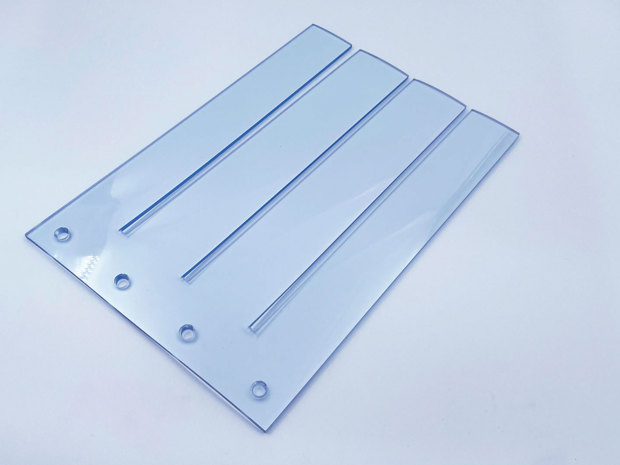 Gennemsigtigt bændelgardin på hvid baggrund.