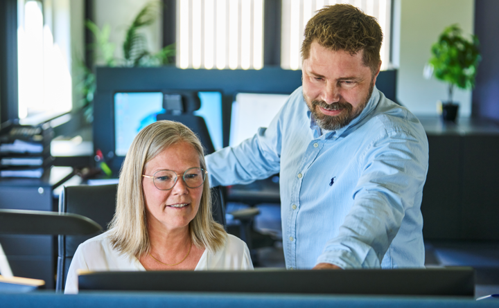 Two colleagues discuss a drawing from a customer.