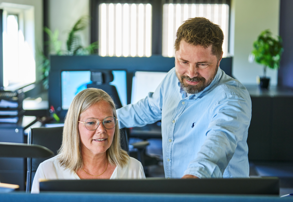 Two colleagues discuss a drawing from a customer.