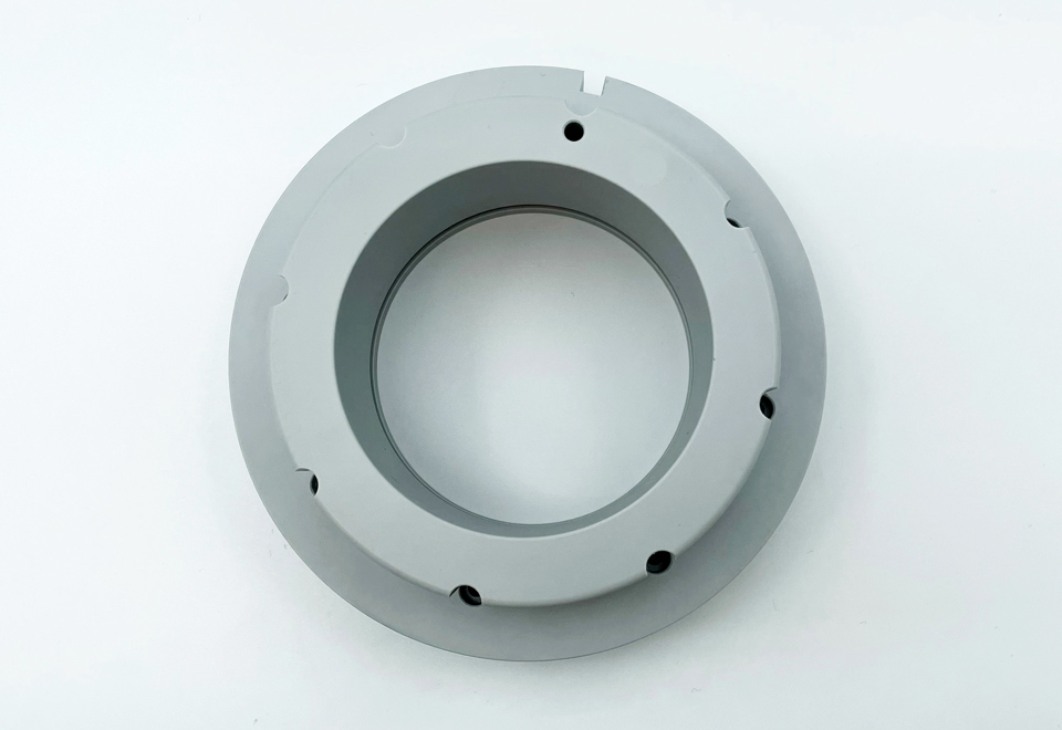 Et gråt PET-P emne, hvor der er tilsat Teflon for at øge glideegenskaberne